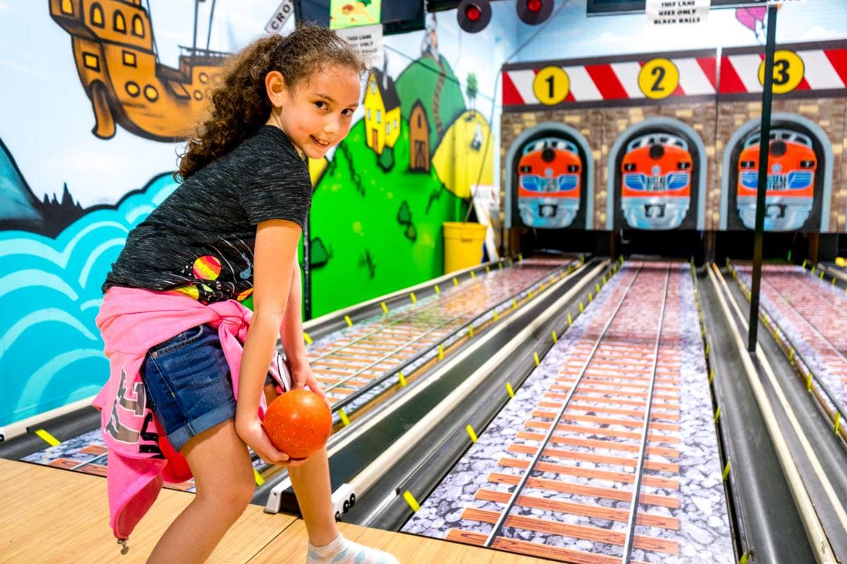 A girl about to bowl on a Kidsports mini lane