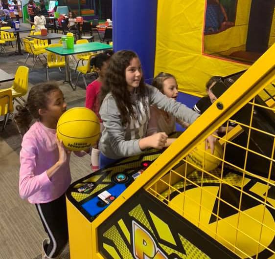 A girl shooting hoops at the basketball arcade game